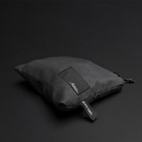 packed up charcoal beach towel shot on dark gray background