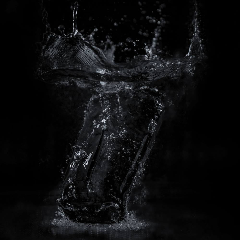 Dry bag splashing into water with black background