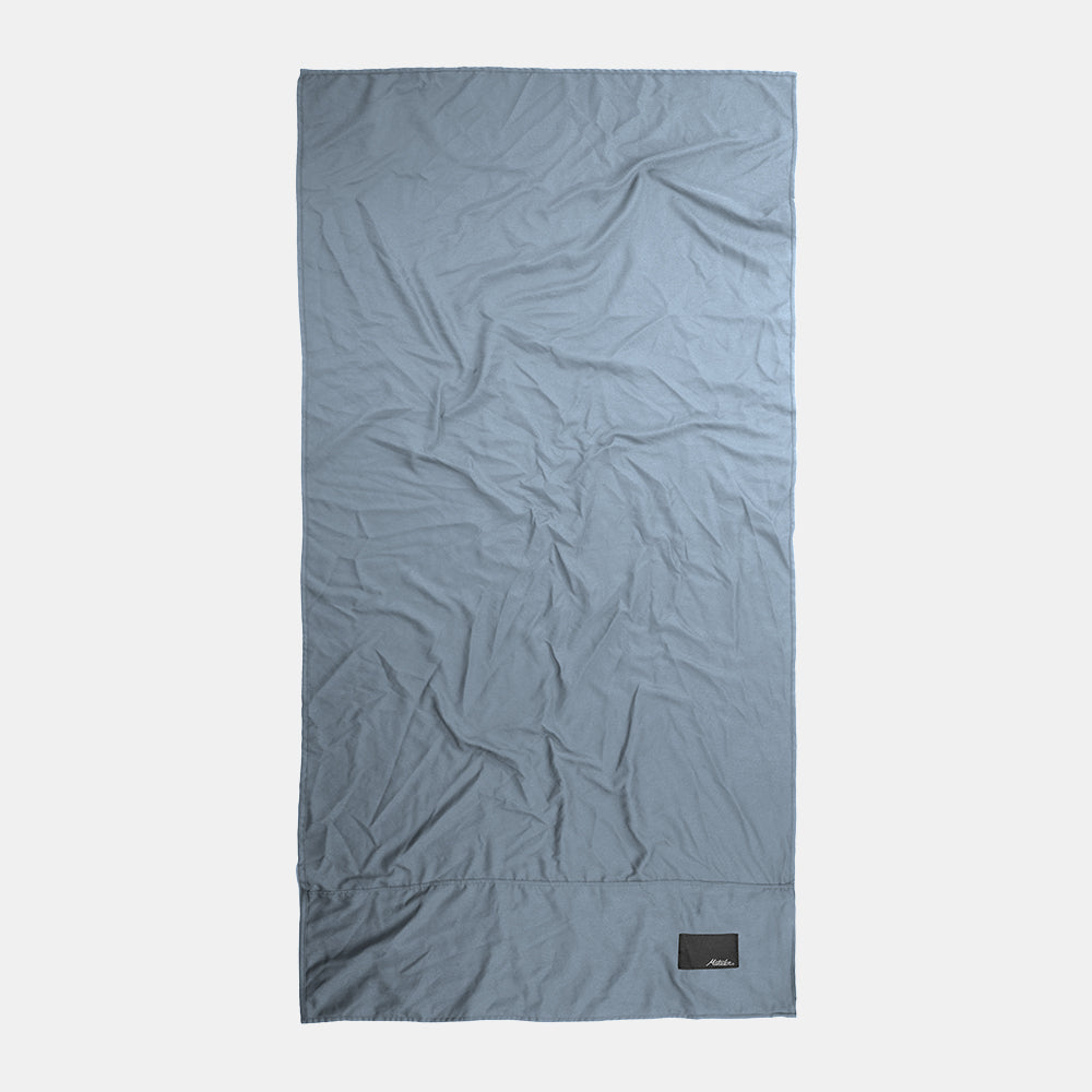 Top-down view of full slate blue towel on light gray background