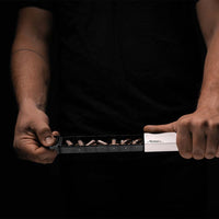 Man holding fully open pill slider on black background