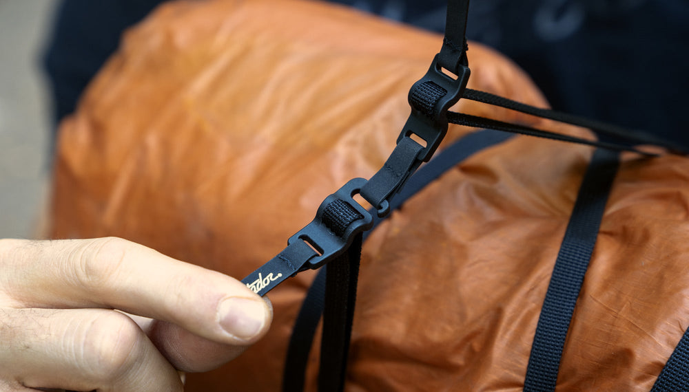 Close up view of Better Tether tabs being pulled against orange tarp