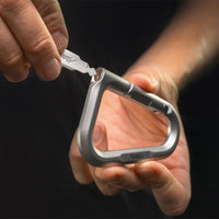 hand holding close up view of metal carabiner with key inserted