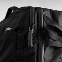 Black silicone earplug case hanging from backpack loop