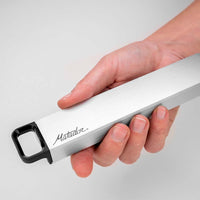 Hand holding pill canister on gray background
