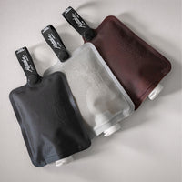 3 toiletry bottles laying on medium gray background