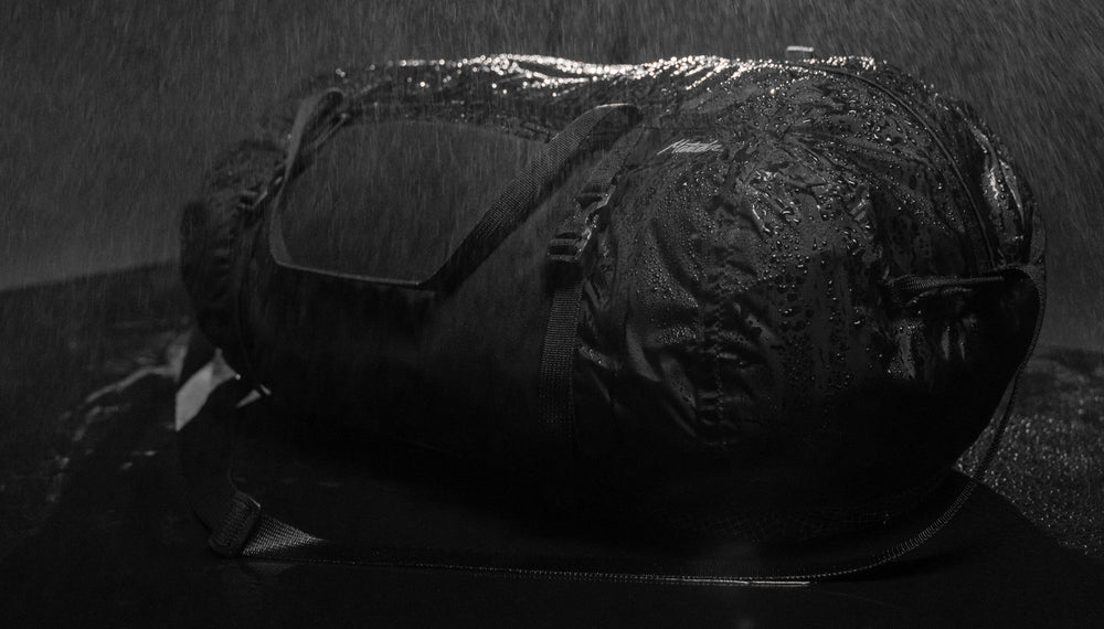 Freefly Duffle on rainy black, covered in beaded water