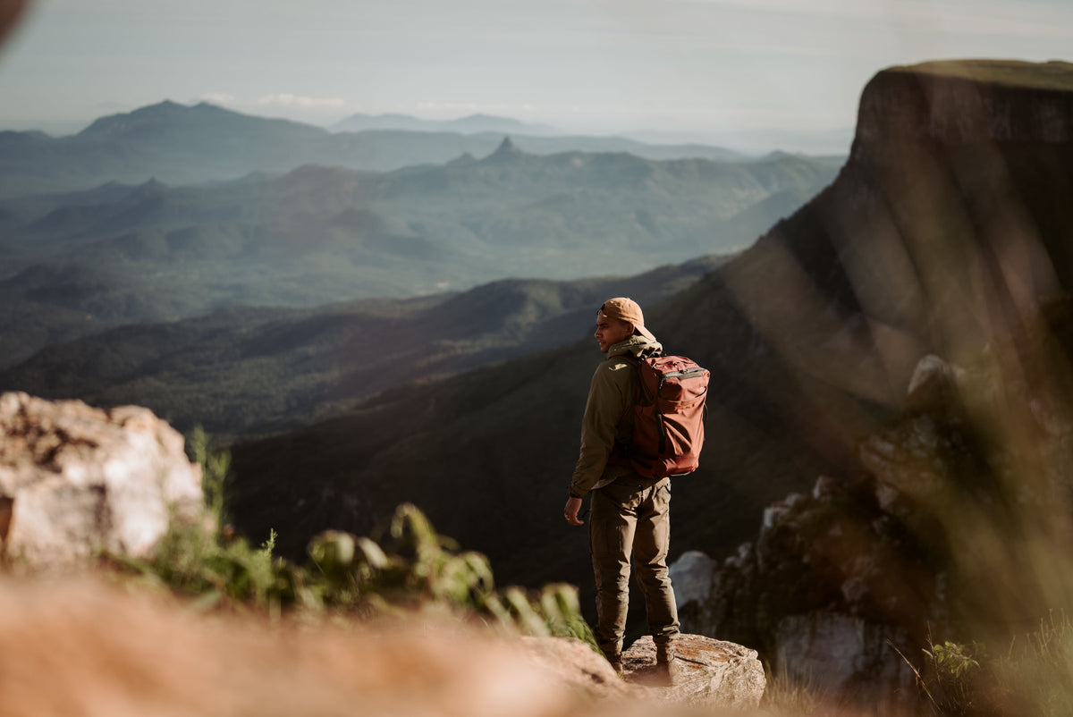 Man overlooking mountains, wearing a garnet GlobeRider35 Travel Pack