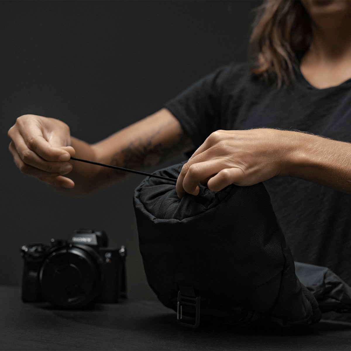 Woman cinching closed the top opening of the base layer