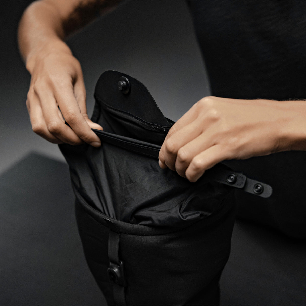 Hands folding over the roll-top closure