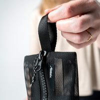 close up view of hand holding the hang loop of mesh bag