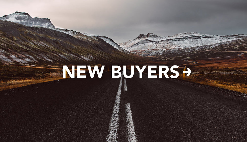 Shot down road of dramatic snowy mountain scape with text: New Buyers
